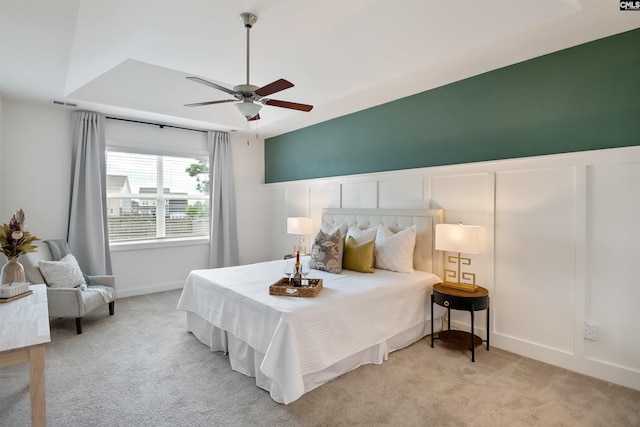 bedroom featuring carpet floors, a decorative wall, and a ceiling fan