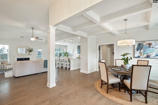 dining space featuring ceiling fan, coffered ceiling, beam ceiling, dark wood-style floors, and a fireplace