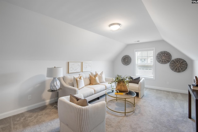 living room with baseboards, lofted ceiling, and carpet