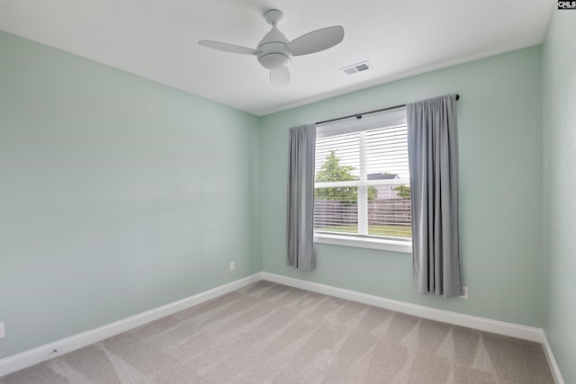 spare room with baseboards, light colored carpet, and a ceiling fan