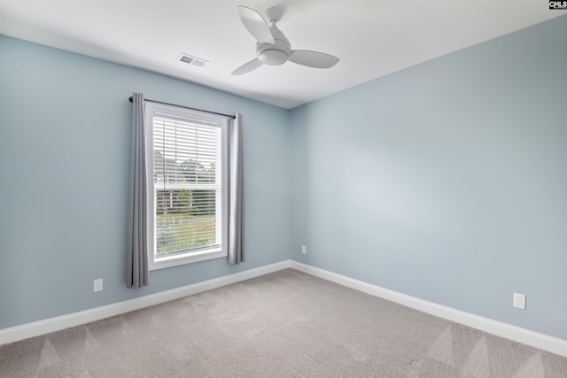 carpeted empty room with a ceiling fan and baseboards