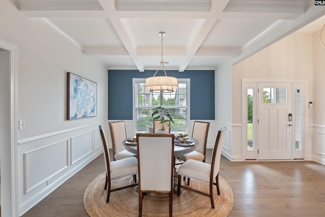 dining space with a decorative wall, beamed ceiling, coffered ceiling, dark wood-style flooring, and a chandelier