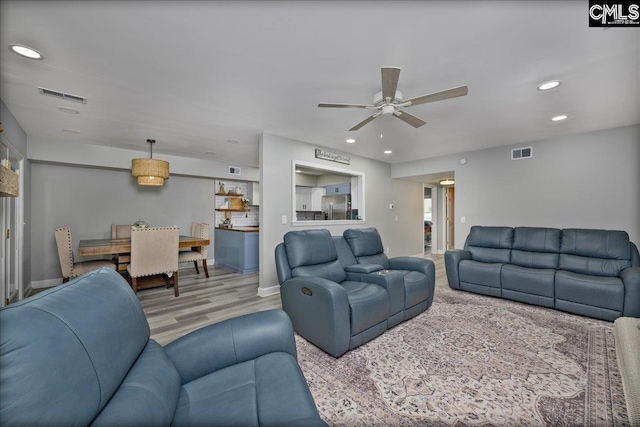 living room with a ceiling fan, recessed lighting, wood finished floors, and baseboards