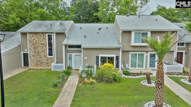 view of front of house with a front lawn and roof with shingles