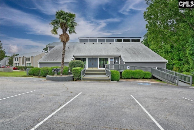 view of building exterior with uncovered parking and fence