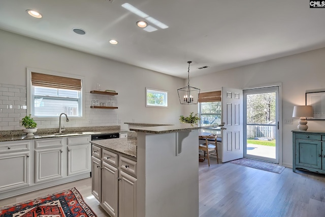 165 Wahoo Cir, Irmo, SC 29063 - kitchen featuring a sink, light wood finished floors, stone countertops, tasteful backsplash, and recessed lighting