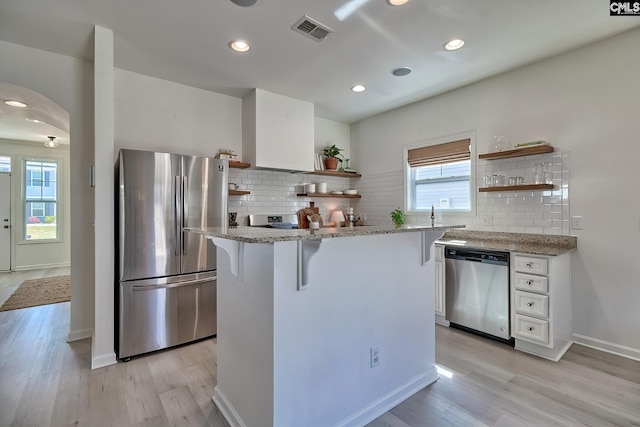 165 Wahoo Cir, Irmo, SC 29063 - kitchen featuring appliances with stainless steel finishes, open shelves, white cabinets, light wood-style floors, and backsplash