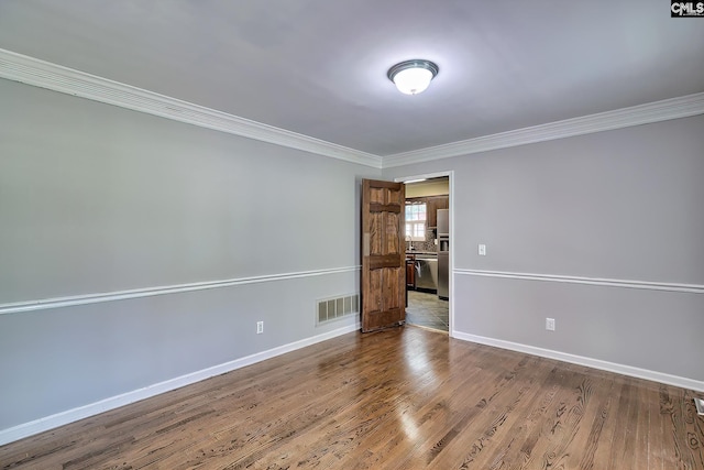 empty room featuring crown molding, baseboards, and dark wood-style flooring