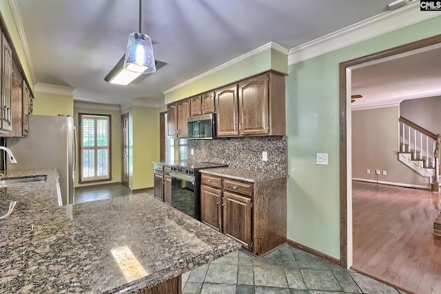 kitchen with appliances with stainless steel finishes, ornamental molding, baseboards, dark stone countertops, and tasteful backsplash