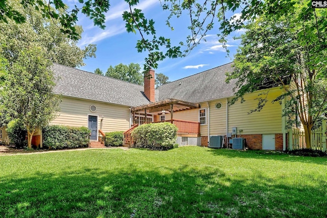 back of property with a pergola, a lawn, a chimney, and central AC