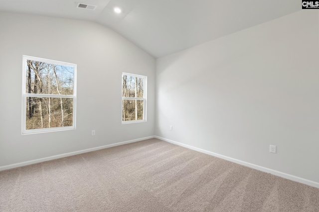 spare room featuring lofted ceiling, carpet floors, and baseboards