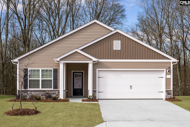 1042 Peaceful Fawn Dr, Elgin, SC 29045 - view of front of home with stone siding, driveway, an attached garage, and a front lawn