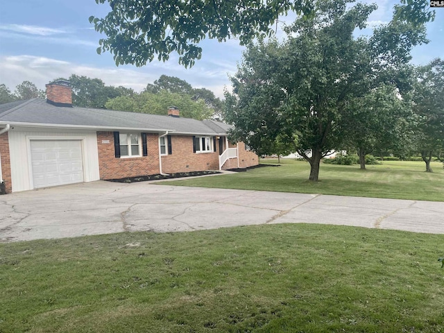 view of front facade with a chimney, driveway, brick siding, and a garage