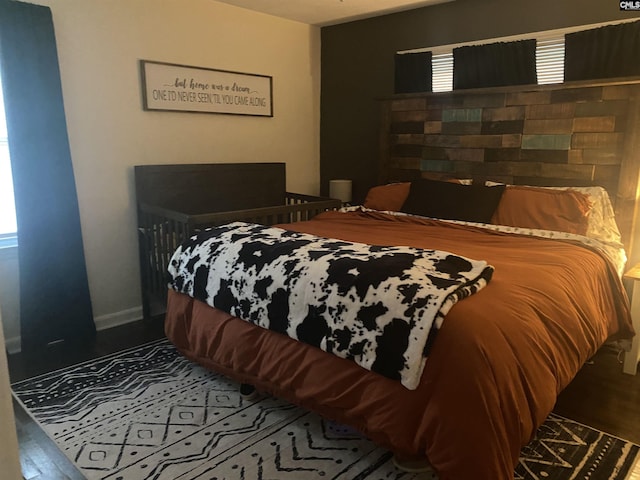 bedroom featuring wood finished floors and baseboards