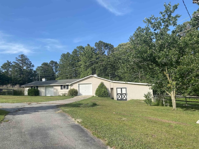 view of front of home with driveway, a garage, an outbuilding, and a chimney