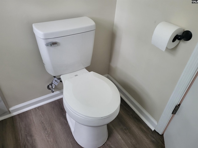 bathroom featuring wood finished floors, baseboards, and toilet