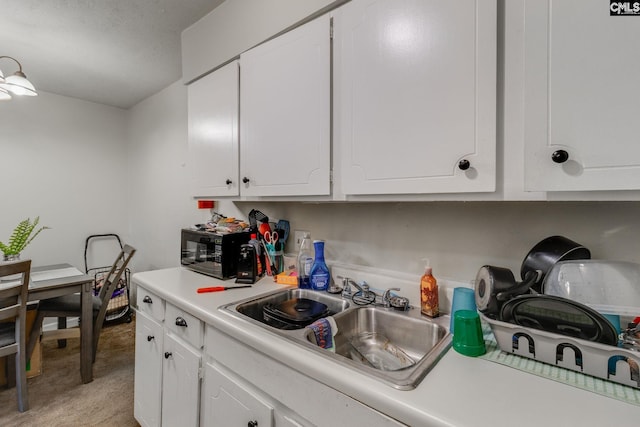1302 Old Manor Rd, Columbia, SC 29210 - kitchen featuring black microwave, a sink, white cabinetry, and light countertops