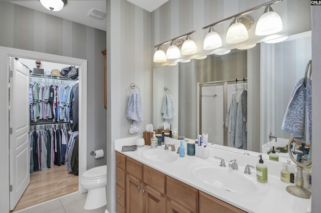 1320 Pulaski St Unit B207, Columbia, SC 29201 - bathroom featuring wallpapered walls, tile patterned flooring, a walk in closet, a shower stall, and double vanity