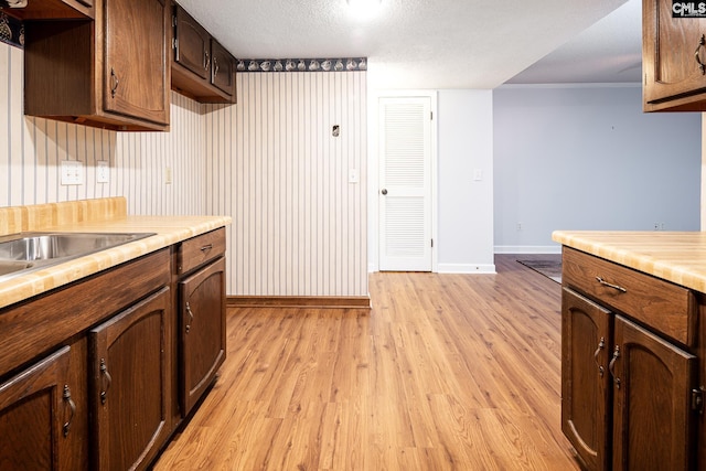 kitchen with baseboards, light wood-style floors, and light countertops