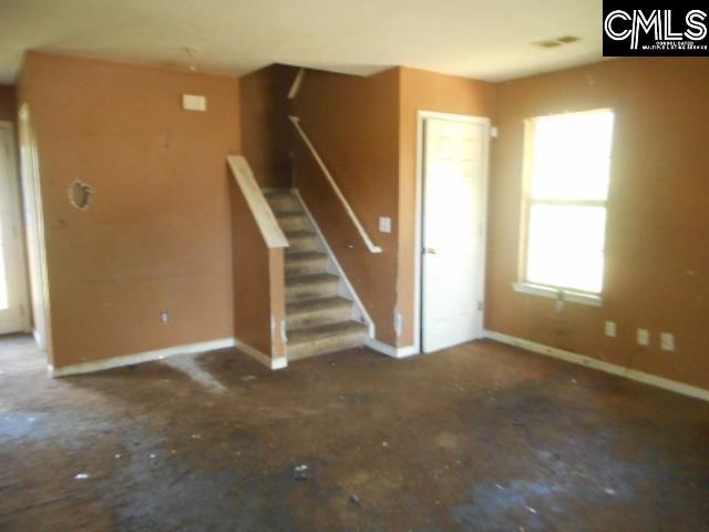 2133 Slighs Ave, Columbia, SC 29204 - unfurnished living room featuring baseboards and stairs