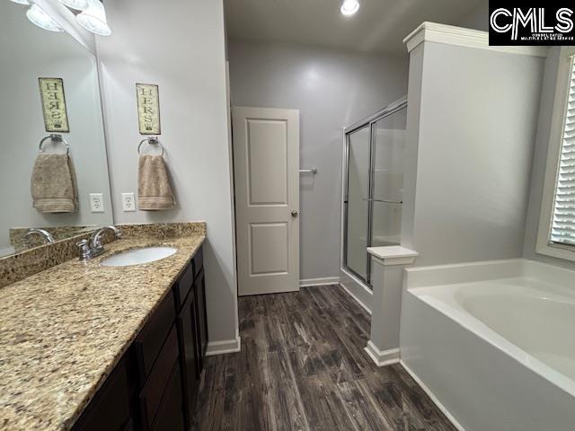 404 Coopers Edge Ln, Blythewood, SC 29016 - full bath with a stall shower, wood finished floors, a garden tub, vanity, and baseboards