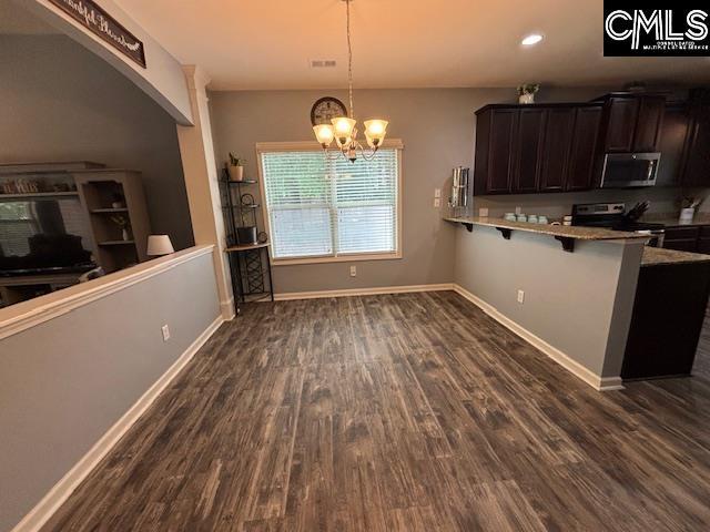 404 Coopers Edge Ln, Blythewood, SC 29016 - kitchen featuring appliances with stainless steel finishes, dark wood-type flooring, a chandelier, a kitchen bar, and recessed lighting