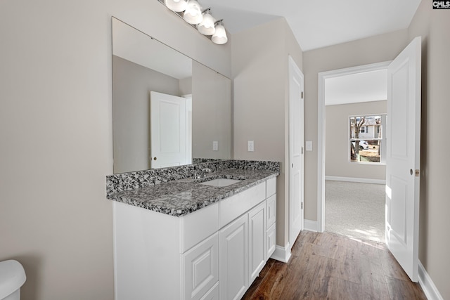 bathroom featuring wood finished floors, vanity, and baseboards