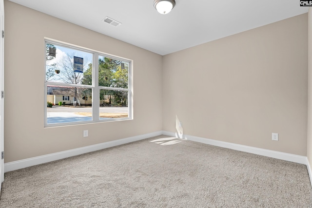 spare room featuring carpet floors and baseboards
