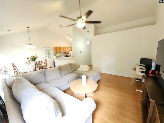 living room featuring ceiling fan, light wood-style flooring, and vaulted ceiling