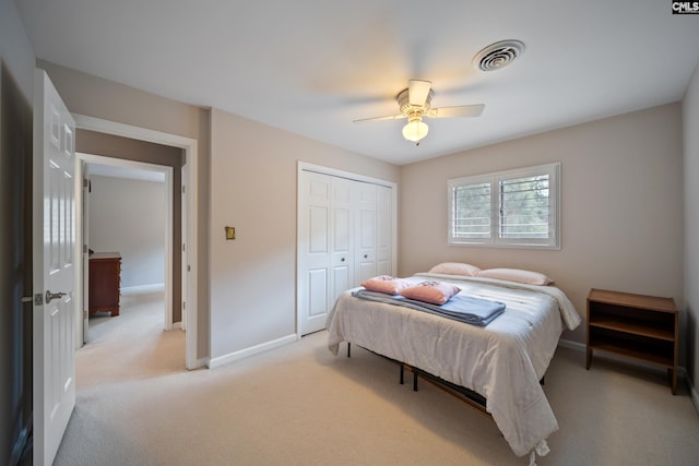 bedroom with light colored carpet, baseboards, a closet, and ceiling fan
