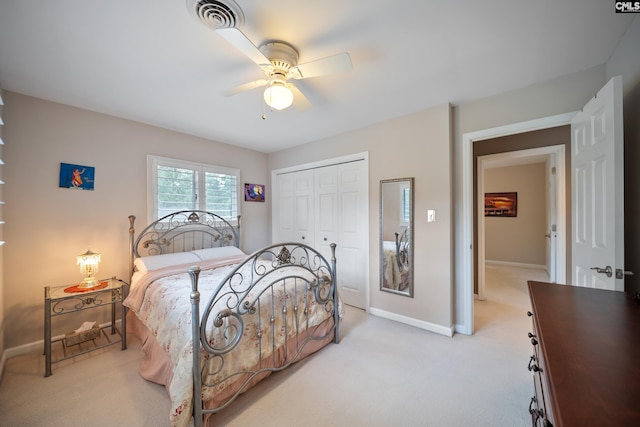 bedroom featuring a closet, light colored carpet, and baseboards