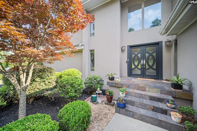 property entrance with stucco siding and french doors