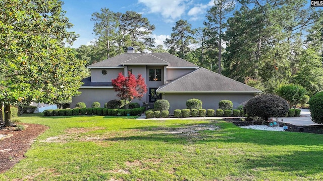 traditional-style home featuring stucco siding and a front yard