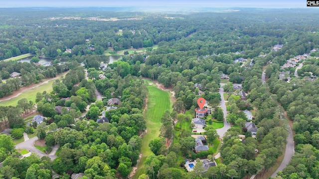 drone / aerial view of a heavily wooded area and a golf course
