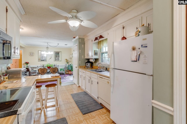 kitchen featuring white appliances, crown molding, a sink, light countertops, and ceiling fan