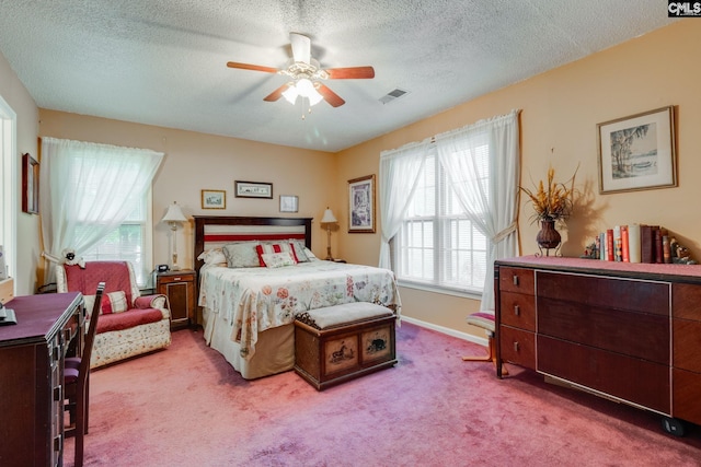 carpeted bedroom with a textured ceiling, a ceiling fan, and baseboards