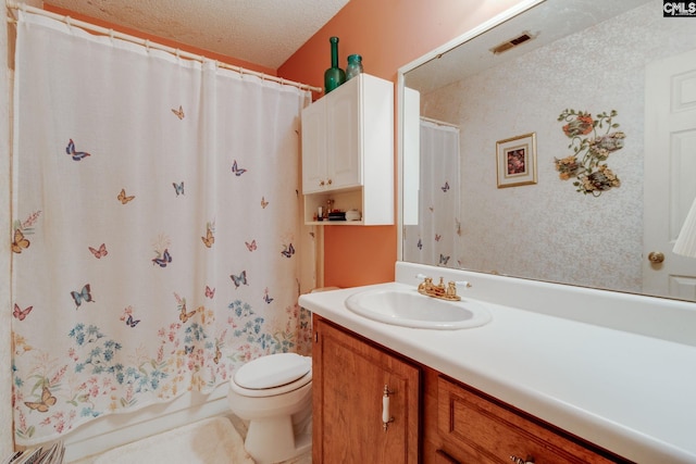 full bathroom featuring vanity, toilet, and a textured ceiling