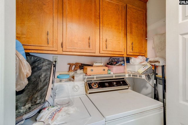 laundry area with washing machine and clothes dryer and cabinet space