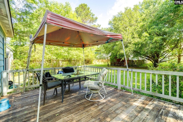wooden deck with outdoor dining area and a gazebo