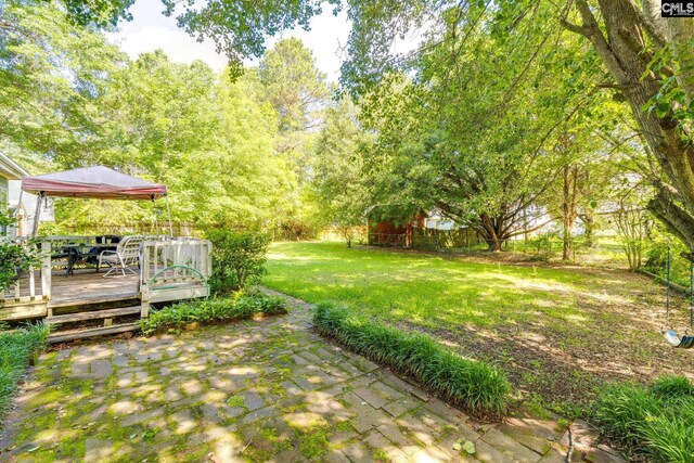 view of green lawn with a deck