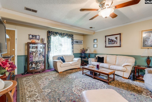 living area featuring ornamental molding, a ceiling fan, and a textured ceiling