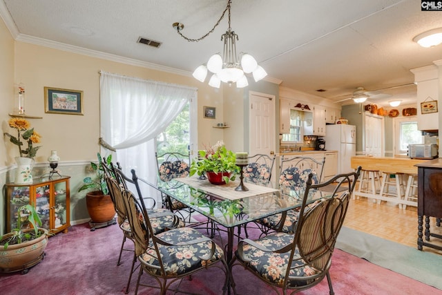 dining space featuring a chandelier, crown molding, and ceiling fan