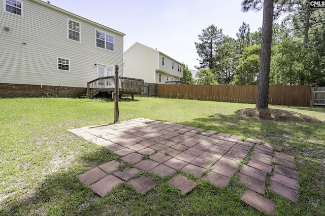 view of yard featuring a wooden deck and a patio