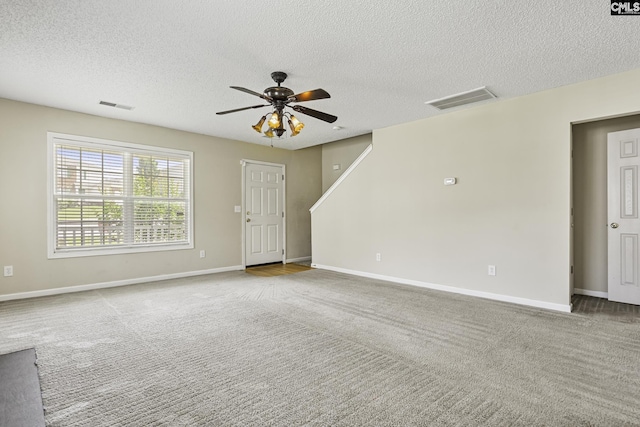 unfurnished living room with carpet floors, ceiling fan, a textured ceiling, and baseboards