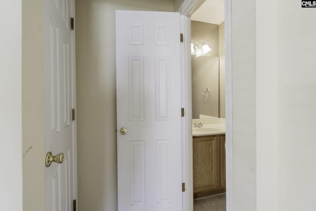 hall featuring a sink and tile patterned floors