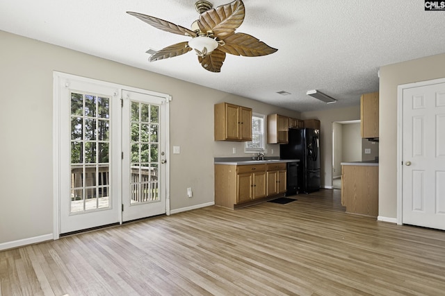kitchen with a ceiling fan, light wood-style floors, black refrigerator with ice dispenser, healthy amount of natural light, and a textured ceiling