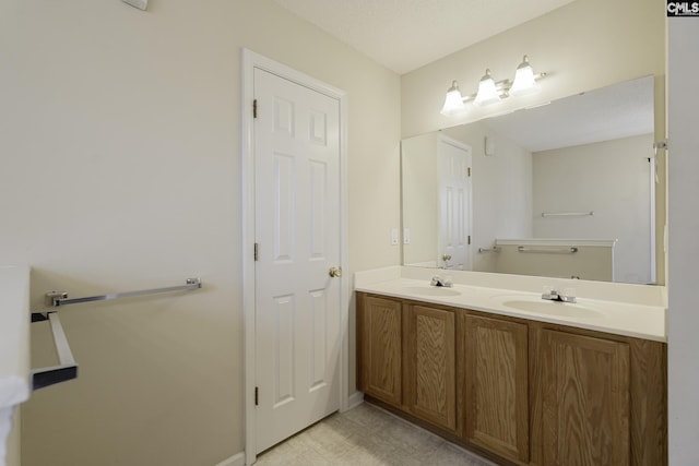 full bath with double vanity and baseboards