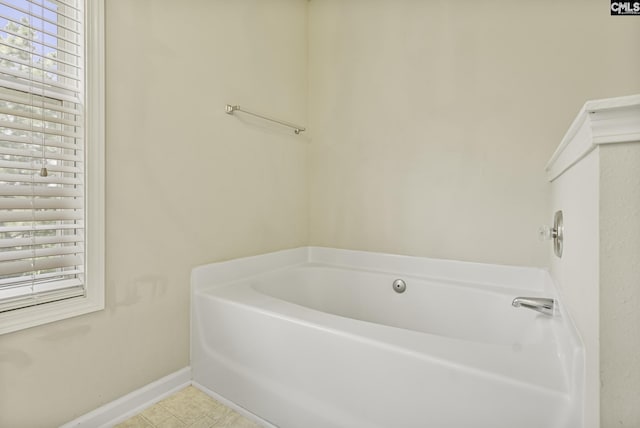 full bathroom with healthy amount of natural light, a garden tub, baseboards, and tile patterned floors