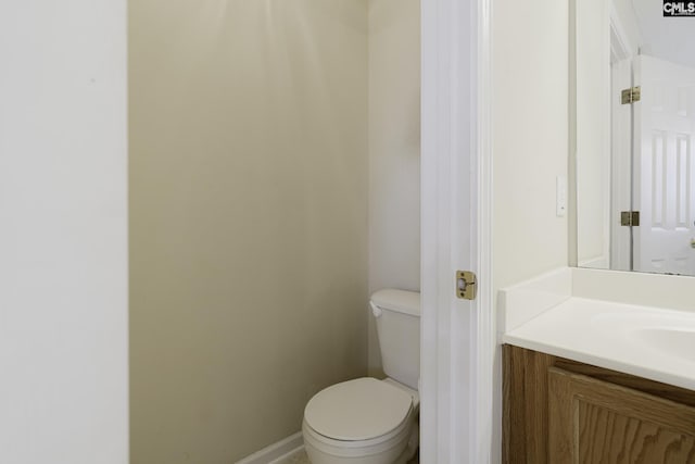 bathroom with vanity, toilet, and baseboards