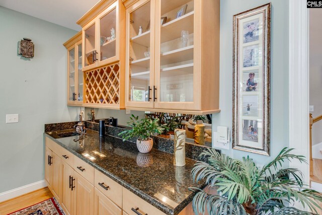 570 Wateree Key Ct, Winnsboro, SC 29180 - kitchen featuring dark stone counters, glass insert cabinets, light wood finished floors, baseboards, and a sink